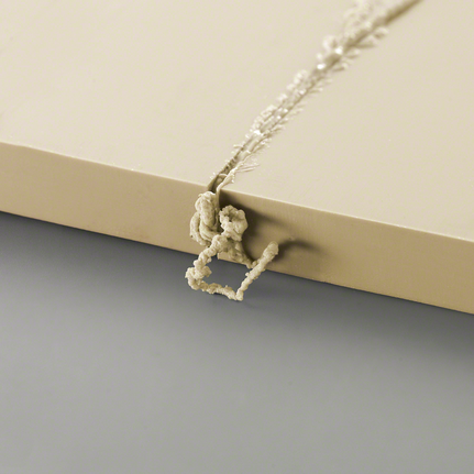 淺色板材鑽孔處突出的多餘材料殘留物。