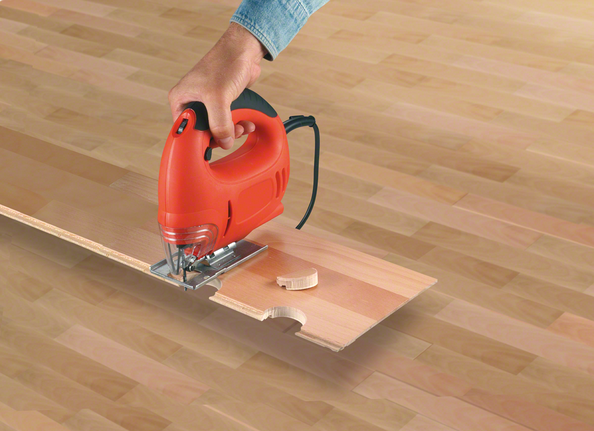 拼圖鋸在複合地板上切割出彎曲的凹口。.