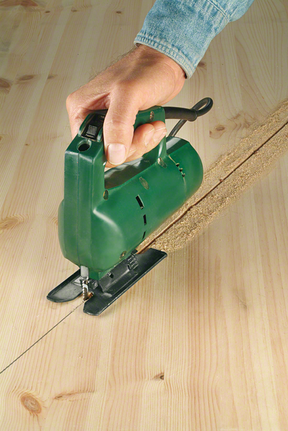 一個人引導拼圖鋸在木板上切出一條直線。.