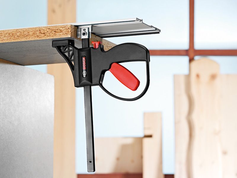 系統附件夾具將木板固定在車間的金屬表面。.