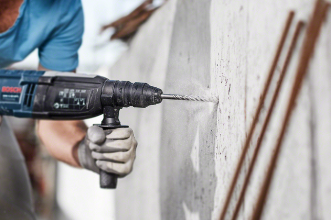 配戴安全設備的人員正在鑽入混凝土牆。.