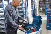 車間裡的一名工人從硬塑膠盒中取出一套無線工具。