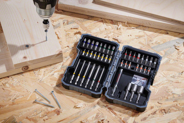 電鑽/起子機放在合板表面上，旁邊是螺絲和木板。