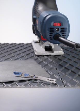 在紋理表面上用曲線鋸切割金屬板。