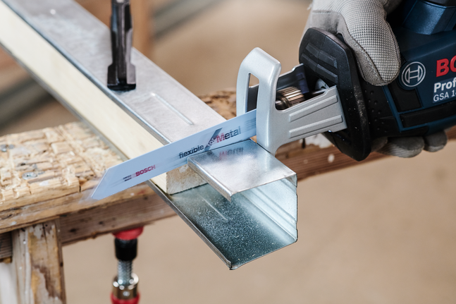 配戴安全裝備的人員使用往復鋸切割金屬槽。