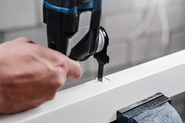 有人使用曲線鋸在白板上切割出一個矩形槽。