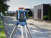 建築物旁的建築工地上的三腳架上安裝的雷射調平工具。