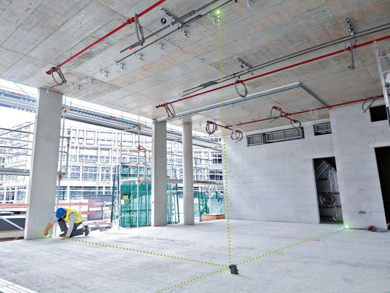 配戴安全設備的人員使用雷射調平工具來對準施工區域內的各點。