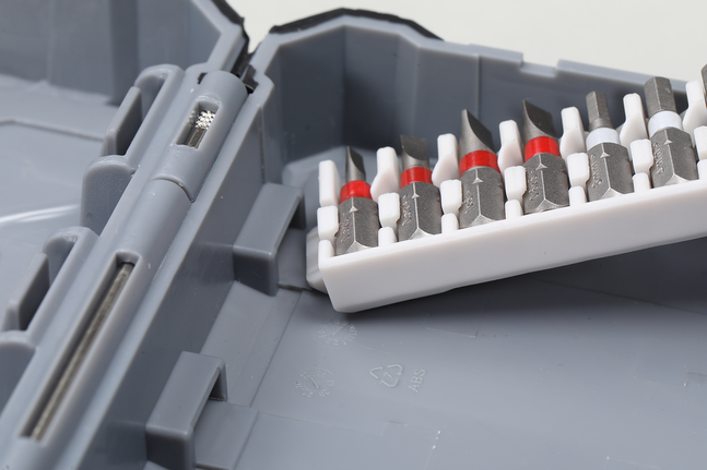 各種螺絲起子頭整齊地擺放在灰色工具箱內的塑膠支架中。