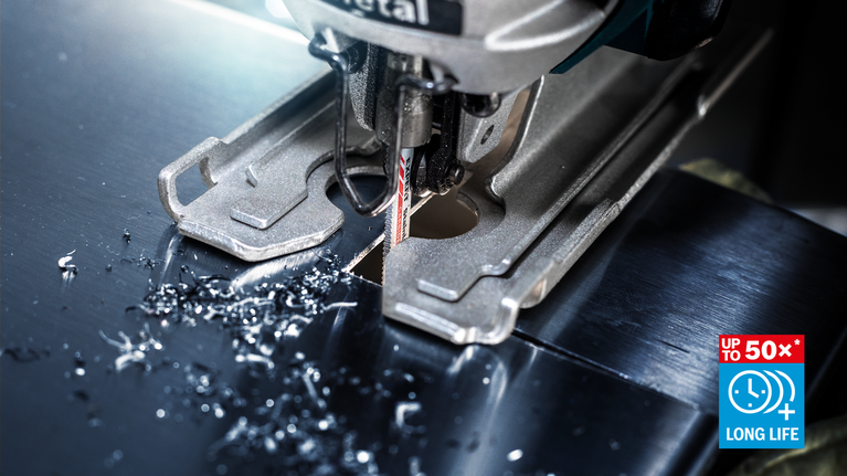 曲線鋸片切割金屬板，表面沾有金屬屑。