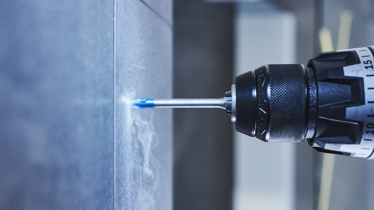 電鑽在瓷磚牆上鑽孔。