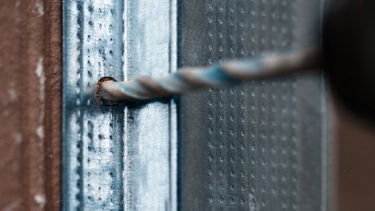 鑽頭在金屬表面鑽孔。