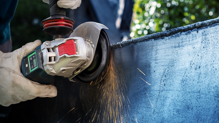 配戴安全設備的人研磨金屬，產生火花。