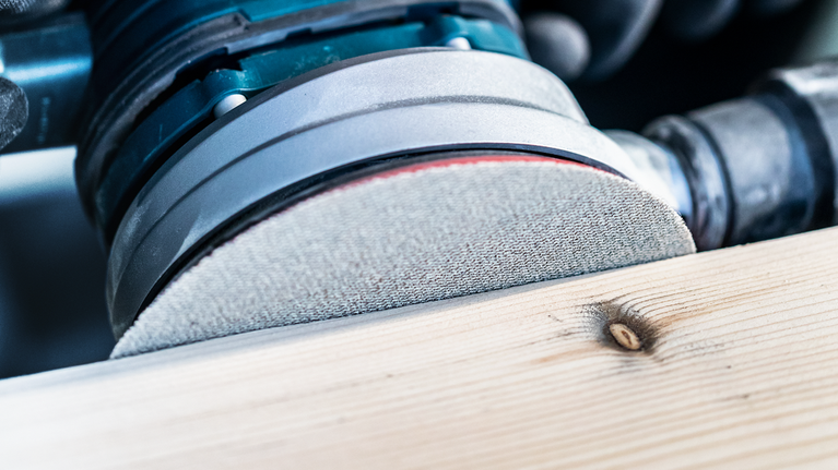 電動砂光機打磨木板表面。