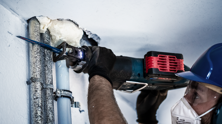 EXPERT ‘Multi Material’ S 956 XHM 軍刀鋸 1 件式 一名配戴安全設備的人員使用往復鋸切割金屬管路。