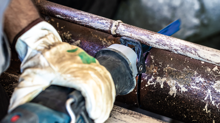 EXPERT ‘Thick Tough Metal’ S 1255 CHC 軍刀鋸 1 件式 一名配戴安全設備的人用往復鋸切割生鏽的金屬管。