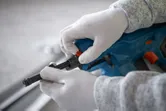 配戴安全設備的人員正在調整無線混凝土釘槍。.