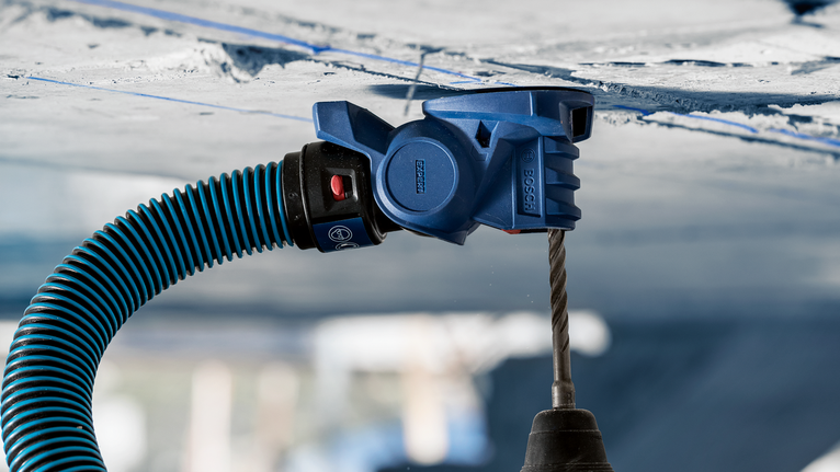 除塵裝置連接到鑽頭，在混凝土天花板上鑽孔。