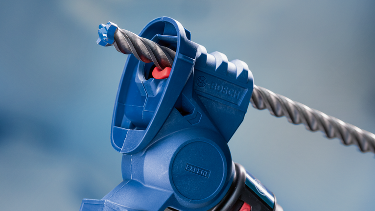 特寫鏡頭：藍色電動工具配件，其中裝有石工鑽頭。