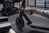 一個人用無線螺絲起子調整電動滑板車的車把。