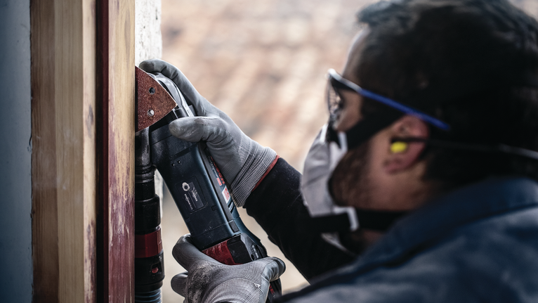 PRO F460 砂紙,93 x 93 mm,G60、G80、G120、G180、G240,10 件 配戴安全設備的人員使用電動工具打磨木製框架。