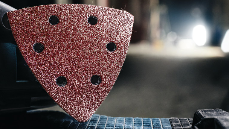 附在電動工具上的三角形砂磨墊的詳細視圖。