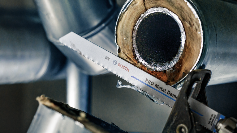 往復鋸片在工業環境中切割金屬管道。