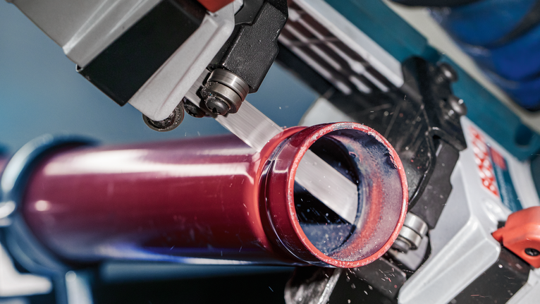 電動工具切割了一根紅色金屬管。