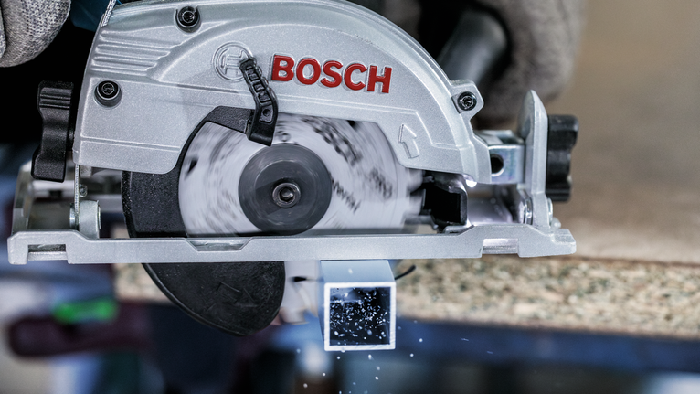 配戴安全設備的人員使用圓鋸切割金屬方管。