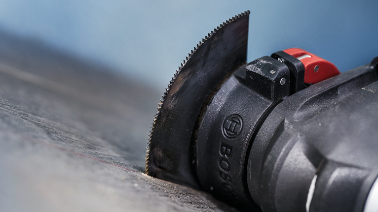 帶有直刀片的振盪多功能工具可切割深色表面。