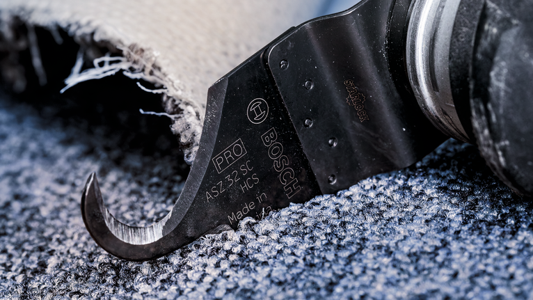 振盪切割工具沿著紋理地板修剪地毯。