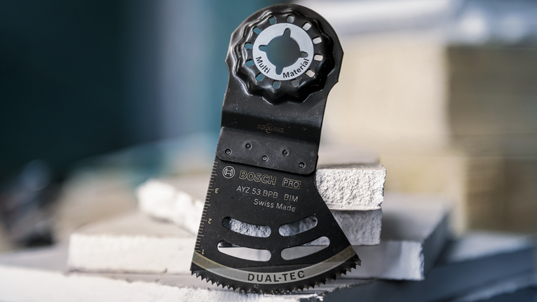 振盪多功能工具刀片直立在堆疊的建築面板上。