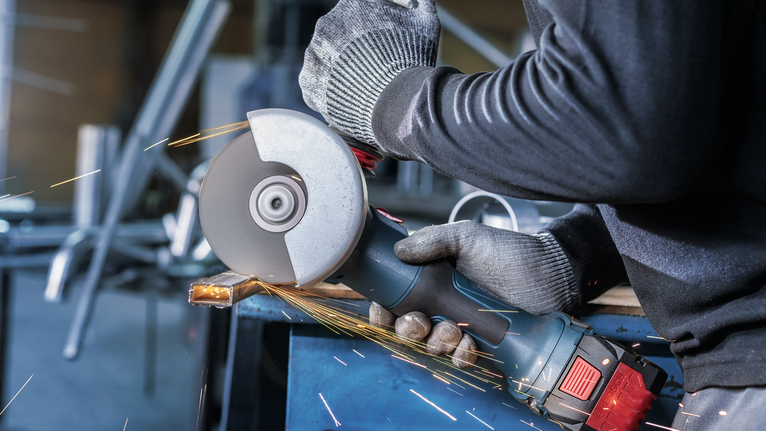 配戴安全設備的人研磨金屬，產生火花。