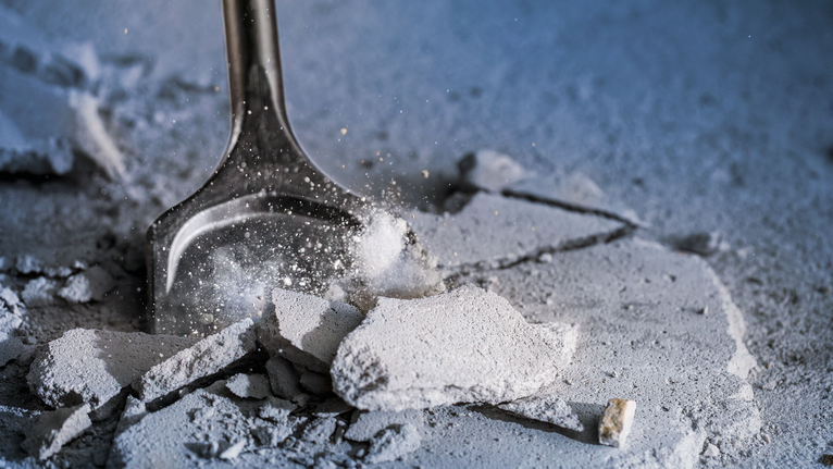 鑿子破碎建築工地上的混凝土碎片。