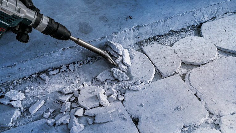 拆除工具正在拆除建築工地上的混凝土磚。