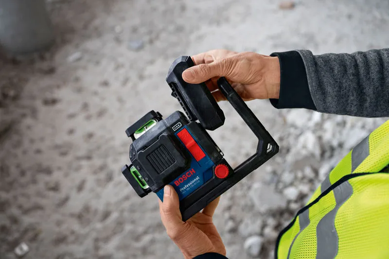 一名配戴安全設備的人員在施工現場調整雷射調平工具。.