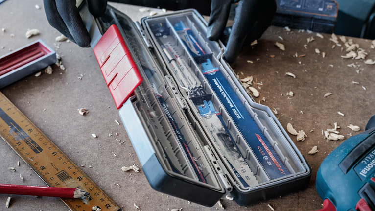 配戴安全設備的人員在工作台上打開鋸片盒。