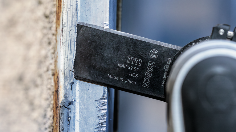 振動工具刀片切割塗漆的木製框架。