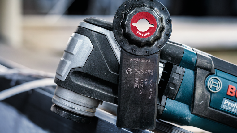 帶有刀片附件的振盪多功能工具用於切割塑膠材料。