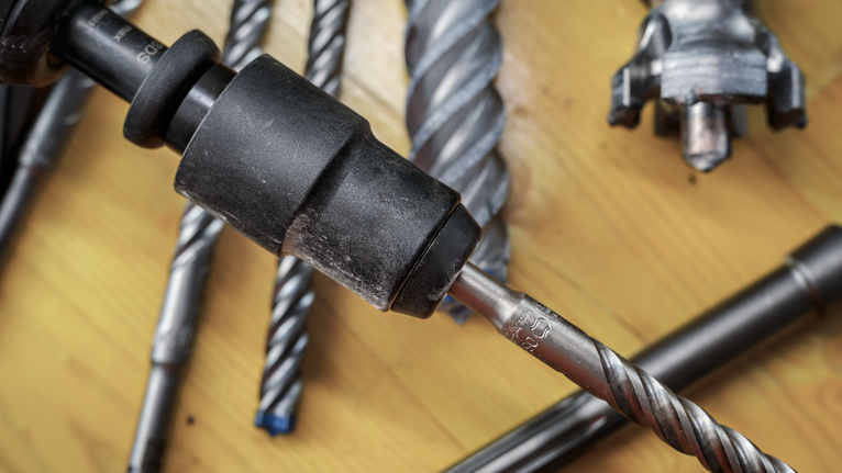 PRO 鎚鑽轉接頭,SDS max 對 SDS plus 木質表面上各種金屬鑽頭和鑽夾頭的特寫。