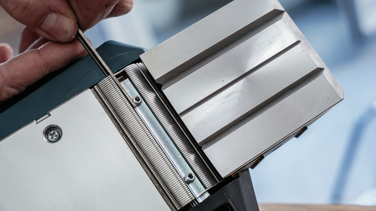 人員使用工具調整金屬刨刀。.