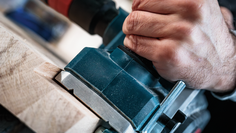 人們使用電動工具來塑造木材。