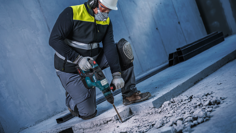 PRO SDS plus-4C 鑿子尖角鑿刀,160 mm 一名佩戴安全設備的人員使用旋轉錘破碎混凝土。