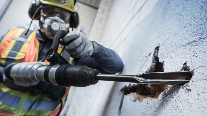 Object #200465508: 3093775_app_web_06 配戴安全設備的人員使用旋轉錘打破混凝土牆。