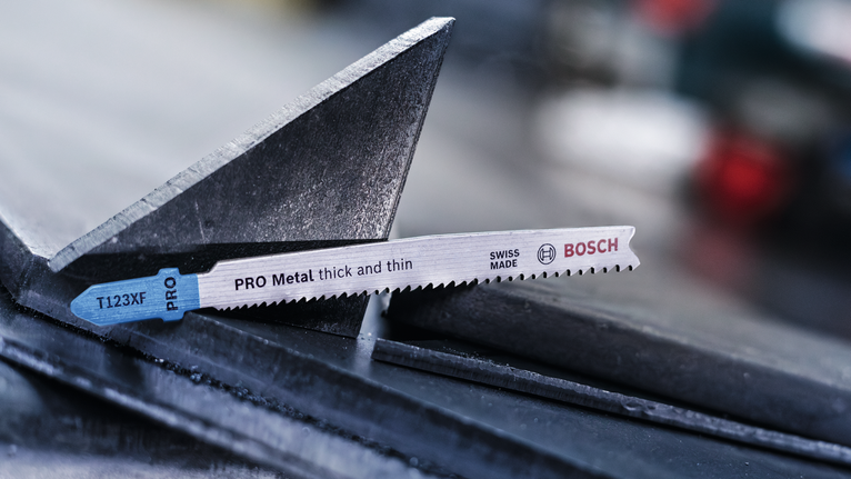 PRO Metal thick and thin T123XF 線鋸片,100 mm,3 件 在工業環境中,拼圖鋸刀片放置在金屬樑上。