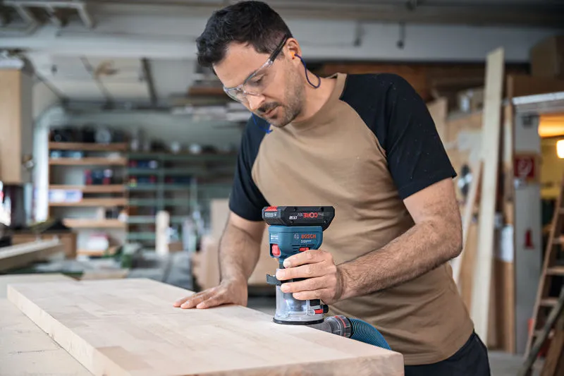 一名配戴安全設備的人員使用無線掌上路由器對木板的邊緣進行佈線。.