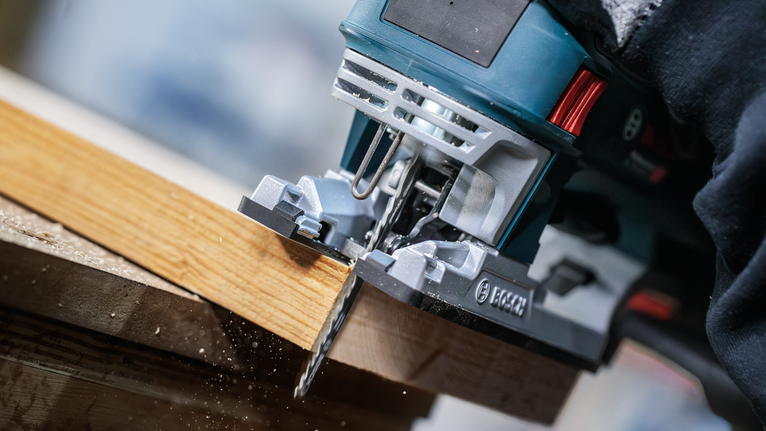 PRO Wood precise T144DP 線鋸片,100 mm,5 片 一名佩戴安全設備的人使用曲線鋸切割木板。