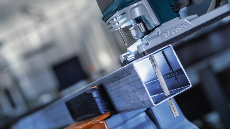 車間裡，電動工具正在切割金屬樑。