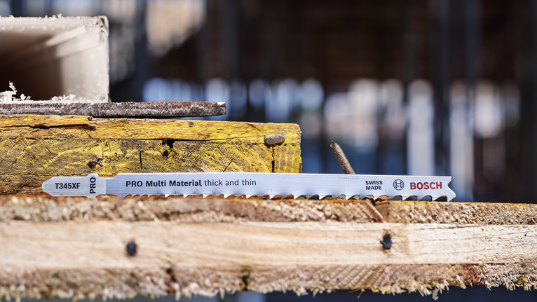 PRO Multi Material 厚薄通用款 T345XF 線鋸片,132 mm,3 件 拼圖鋸刀片放在建築工地堆疊的木板上。