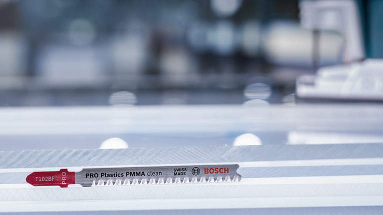 拼圖鋸刀片放在車間的透明塑膠板上。